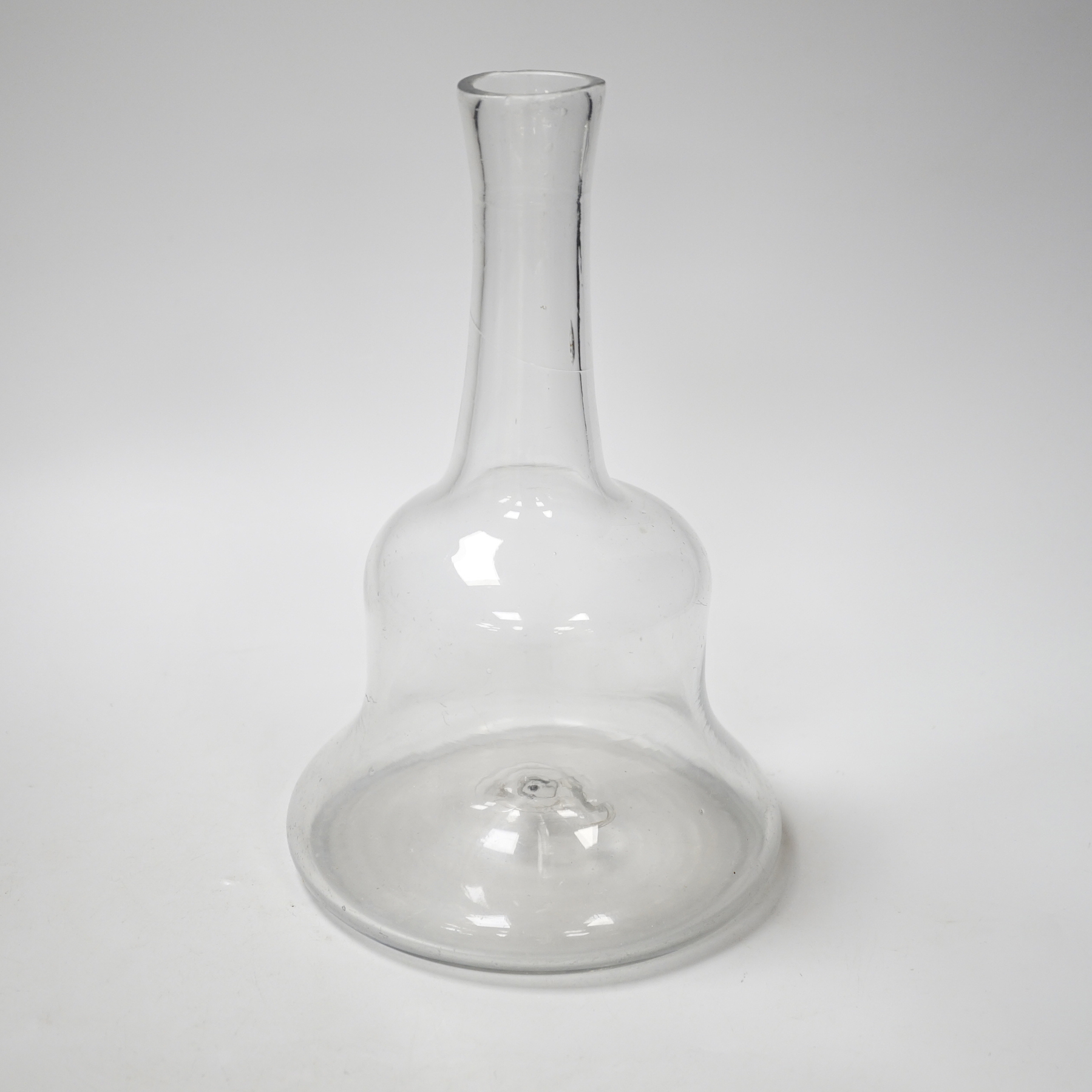 An early 18th century English lead crystal serving bottle, of long shaft and globe in the form of a bell, 23.5cm high